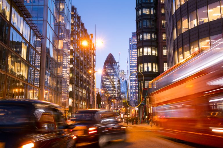 London street with buses and traffic - with Gherkin building in background